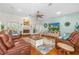 Cozy living room featuring a fireplace, hardwood floors, a ceiling fan, and plenty of natural light at 1309 Wicklow Ln, Ormond Beach, FL 32174
