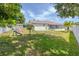 Spacious backyard with a swing set and mature trees at 1343 Rocky Rd, Kissimmee, FL 34744