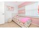 Bright bedroom featuring playful decor, pink accents and ample natural light at 1343 Rocky Rd, Kissimmee, FL 34744