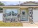 Close-up view of the front entrance, showing stone detailing and updated windows at 1343 Rocky Rd, Kissimmee, FL 34744