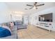 Open living space with gray sectional, entertainment center, and seamless flow to the dining area at 1343 Rocky Rd, Kissimmee, FL 34744