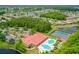 Aerial view of community clubhouse, pools, tennis courts, and surrounding neighborhood at 1481 Areca Palm Dr, Port Orange, FL 32128