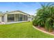 Expansive backyard featuring tropical landscaping and the partially screened lanai at 1481 Areca Palm Dr, Port Orange, FL 32128