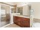 Bathroom featuring a tiled shower, granite counters with dual sinks, and a large mirror at 1481 Areca Palm Dr, Port Orange, FL 32128