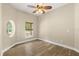 Bedroom features wood-look floors, a ceiling fan, and a window with a view of the yard at 1481 Areca Palm Dr, Port Orange, FL 32128