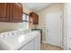 Bright laundry room with washer, dryer, upper cabinets, sink, and tile flooring at 1481 Areca Palm Dr, Port Orange, FL 32128