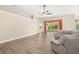 Spacious living room featuring light vinyl flooring, a ceiling fan, and sliding glass doors with access to the backyard at 1481 Areca Palm Dr, Port Orange, FL 32128