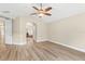 Spacious main bedroom featuring wood-look floors, a ceiling fan, and an attached bathroom through an arched doorway at 1481 Areca Palm Dr, Port Orange, FL 32128