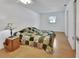 A bright bedroom with laminate floors, a ceiling fan, and a window at 1590 Urbana Ave, Deltona, FL 32725