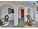 Charming front porch with arched openings and a pop of color from the red front door at 1590 Urbana Ave, Deltona, FL 32725