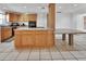 Bright kitchen featuring wooden cabinetry, an island cooktop, and tile flooring, offering a functional and inviting space at 1590 Urbana Ave, Deltona, FL 32725