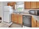 Kitchen featuring wood cabinets, stainless steel sink, and modern appliances, providing a functional and stylish cooking space at 1590 Urbana Ave, Deltona, FL 32725