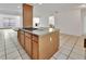 Functional kitchen island with cooktop and wooden cabinetry provides a central hub in this open-concept kitchen and living space at 1590 Urbana Ave, Deltona, FL 32725