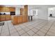 Open-concept kitchen featuring wood cabinets, cooktop island, and tile flooring, blending style and functionality seamlessly at 1590 Urbana Ave, Deltona, FL 32725
