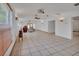 Open-concept living room with tile floors, ceiling fans, wall sconces, and large windows providing ample natural light at 1590 Urbana Ave, Deltona, FL 32725