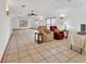 Bright living room featuring tile flooring, neutral tones, ample seating, and large windows that offer abundant sunlight at 1590 Urbana Ave, Deltona, FL 32725