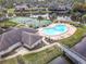 Aerial view of a community pool, tennis court, and waterfront area surrounded by palm trees at 16 Big Buck Trl, Ormond Beach, FL 32174