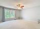 Large bedroom features neutral walls and carpet, a ceiling fan, and a large window at 16 Big Buck Trl, Ormond Beach, FL 32174