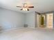 Large bedroom boasts neutral walls and carpet, a ceiling fan, and an open bathroom at 16 Big Buck Trl, Ormond Beach, FL 32174