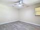 Neutral bedroom featuring wood-look floors, a window, and a ceiling fan at 16 Big Buck Trl, Ormond Beach, FL 32174