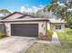 Inviting townhome with a spacious garage, stone accents, manicured lawn, and walkway to entrance at 16 Big Buck Trl, Ormond Beach, FL 32174
