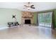 Living room with stone fireplace and sliding glass doors at 16 Big Buck Trl, Ormond Beach, FL 32174
