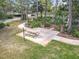 Aerial view of a wooden picnic table in a lush green grassy area surrounded by mature trees at 16 Big Buck Trl, Ormond Beach, FL 32174