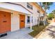 Inviting townhome exterior with palm trees, colorful doors, and well-maintained landscaping at 1600 S Palmetto Ave # 105, South Daytona, FL 32119