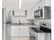 Modern kitchen featuring white cabinets, granite countertops, and stainless steel appliances at 1600 S Palmetto Ave # 105, South Daytona, FL 32119