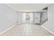 Bright living room with tile floors, a staircase, and sheer-curtained window at 1600 S Palmetto Ave # 105, South Daytona, FL 32119