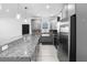Open kitchen features stainless steel appliances, granite counters, farmhouse sink and wood-look floors at 1626 Lansfield Ave, Deltona, FL 32738