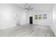 Bright, airy living room featuring modern ceiling fan, wood-look floors, and three windows at 1626 Lansfield Ave, Deltona, FL 32738