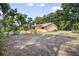 View of house with fenced garden bed from the backyard surrounded by leafy trees at 1690 S Adelle Ave, Deland, FL 32720