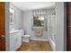 This bathroom features a shower-tub combo and a large window with gray curtains at 1690 S Adelle Ave, Deland, FL 32720
