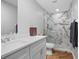 Modern bathroom featuring a marble-tiled shower, white vanity, and earthy floors at 1690 S Adelle Ave, Deland, FL 32720