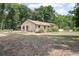 Single-story house surrounded by trees featuring a red door and a brown roof at 1690 S Adelle Ave, Deland, FL 32720
