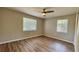 Bedroom with wood-look flooring, ceiling fan, and bright natural light from the two windows at 175 Center St, Daytona Beach, FL 32117