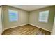 Bright bedroom featuring wood-look flooring, dual windows, and a simple, modern design at 175 Center St, Daytona Beach, FL 32117