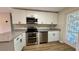 Modern kitchen featuring stainless steel appliances, granite countertops, white cabinets, and stylish door at 175 Center St, Daytona Beach, FL 32117