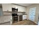 Stylish kitchen with stainless steel appliances, granite countertops, white cabinets, and wood-look flooring at 175 Center St, Daytona Beach, FL 32117