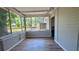 Sunroom featuring large windows, neutral paint and brick work, and wood-look floors at 175 Center St, Daytona Beach, FL 32117