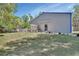 Wide view of the back exterior yard with a metal home, lush green lawn, and privacy fence at 183 Mcgregor Rd, Deland, FL 32720