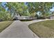 Long driveway leading to a large metal building with ample parking space surrounded by mature trees and greenery at 183 Mcgregor Rd, Deland, FL 32720