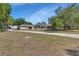 Wide shot of the house exterior with a long driveway and a well-maintained lawn at 183 Mcgregor Rd, Deland, FL 32720