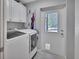 Bright laundry room with washer, dryer, white cabinets, and exterior door at 183 Mcgregor Rd, Deland, FL 32720