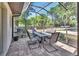 Enclosed screened porch featuring a stone patio with a dining table and chairs at 183 Mcgregor Rd, Deland, FL 32720