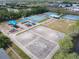 Overhead view of a park with tennis courts, a playground, and a basketball court surrounded by greenery at 1860 Forough Cir, Port Orange, FL 32128