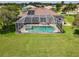 Aerial view of the property showcases the screened pool and lush landscaping at 1860 Forough Cir, Port Orange, FL 32128