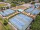 Overhead view of tennis courts with shade structures and landscaping, surrounded by a green community at 1860 Forough Cir, Port Orange, FL 32128