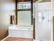 Bathroom featuring a large bathtub, tiled shower and glass block window for added privacy at 1860 Forough Cir, Port Orange, FL 32128